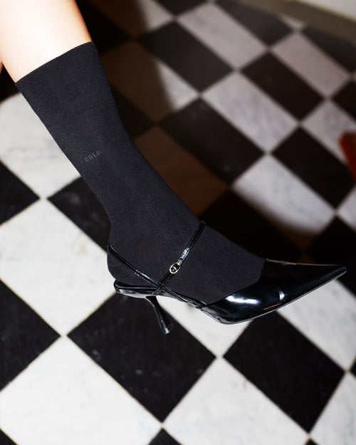 Model wearing Unisex Mid Length Cotton Socks in Black - CDLP