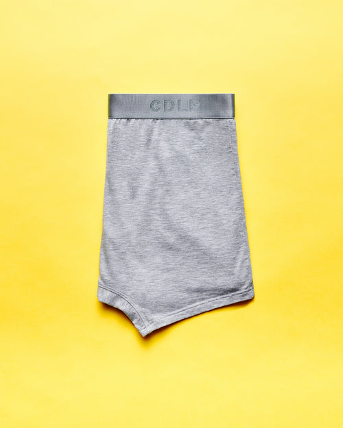 Grey boxer brief with elastic waistband featuring the CDLP logo on a yellow background.