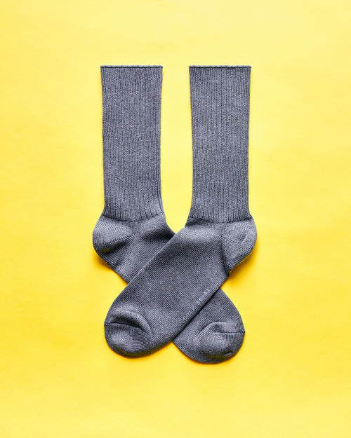 Grey ribbed socks displayed against a yellow background.