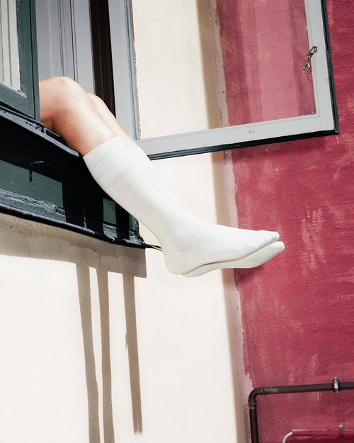 Model wearing Unisex Mid Length Cotton Socks in White - CDLP