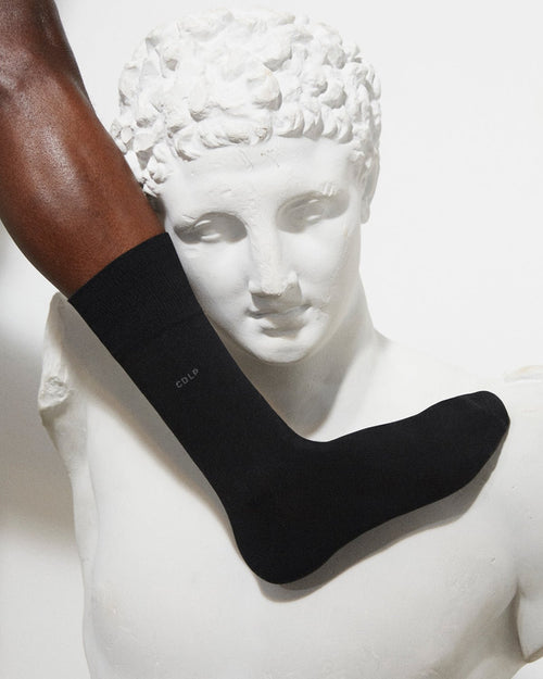 Model wearing Unisex Mid Length Cotton Socks in Black - CDLP