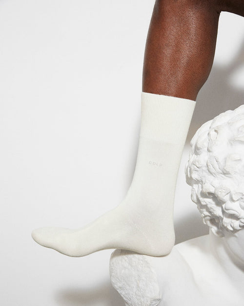 Model wearing Unisex Mid Length Cotton Socks in White - CDLP