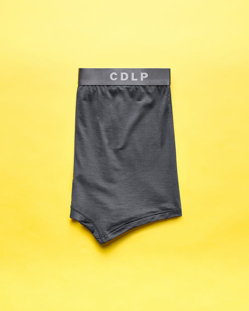 Dark grey boxer brief with elastic waistband featuring the CDLP logo on a yellow background.