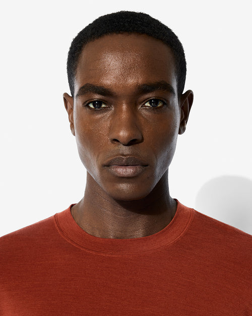 Close-up portrait of a male model wearing the Rust Merino Blend Long Sleeve T-Shirt by CDLP.