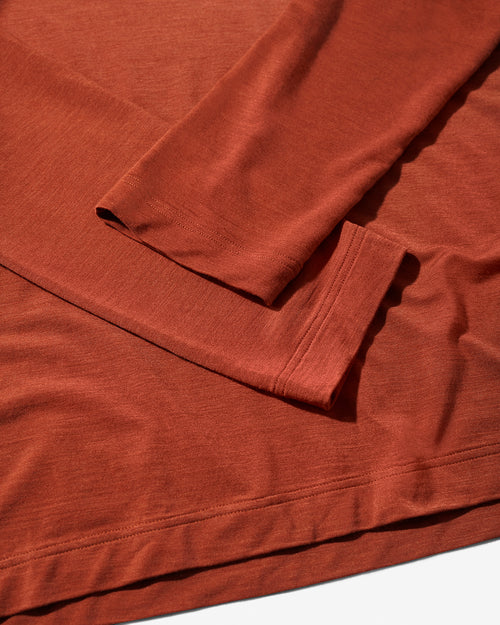 Close-up of the rust-colored Merino Blend Long Sleeve T-Shirt by CDLP, highlighting the fine knit fabric and hem construction.