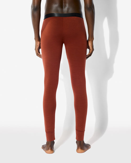 Rear view of a model wearing CDLP Merino Blend Long Johns in Rust against a neutral studio background.