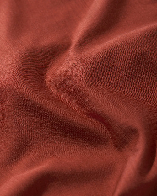 Close-up of the soft Merino Wool and Tencel blend fabric in rust for CDLP Merino Blend Long Johns.