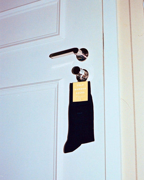 Bamboo Mid-Length Socks hanging on a door handle