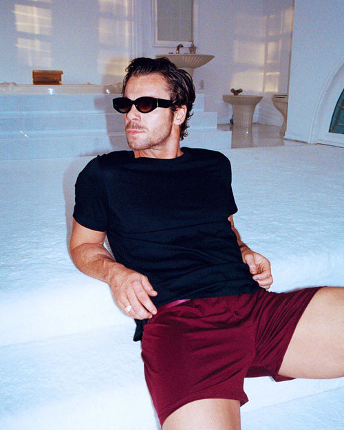 Pierre sitting on the stairs wearing Boxer Shorts in Burgundy and Midweight T-Shirt in Navy Blue