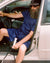Sébastien sitting in the car wearing Home Shorts in Navy Blue